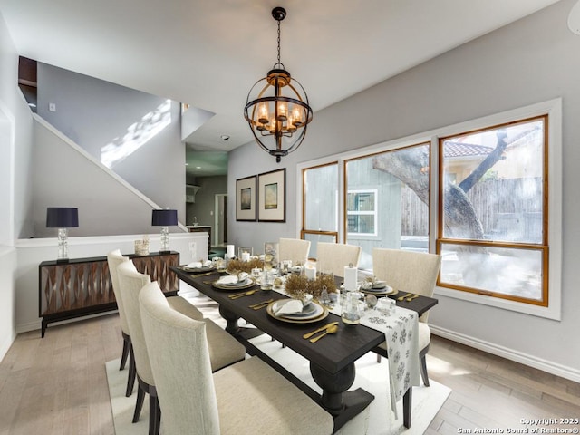 dining area with a healthy amount of sunlight, a notable chandelier, and light hardwood / wood-style floors