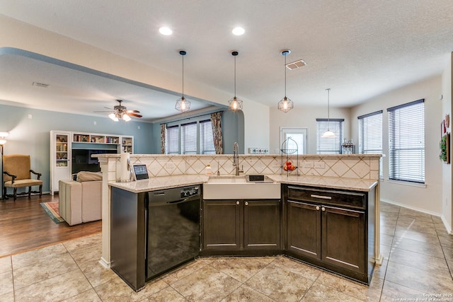 kitchen with sink, dishwasher, hanging light fixtures, dark brown cabinets, and an island with sink