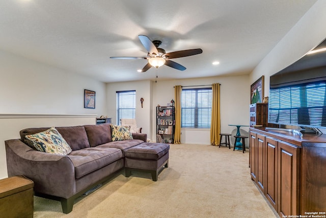 living room featuring light colored carpet and ceiling fan