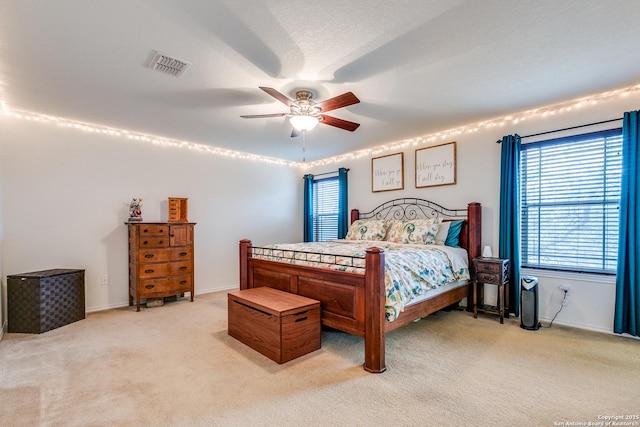 carpeted bedroom with ceiling fan and a textured ceiling