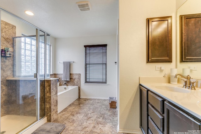 bathroom with vanity and separate shower and tub