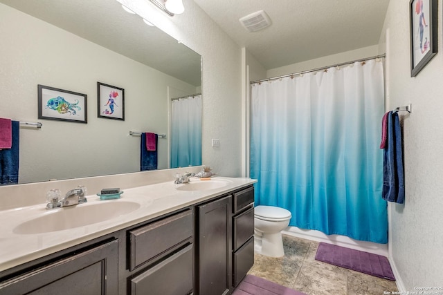 bathroom featuring vanity, toilet, and a textured ceiling