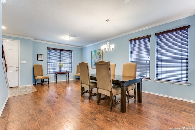 dining room featuring a notable chandelier, ornamental molding, and hardwood / wood-style floors