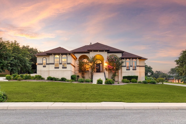 mediterranean / spanish house featuring a lawn