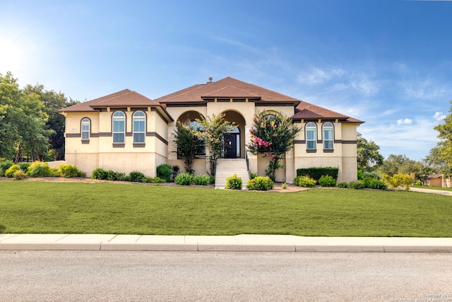 mediterranean / spanish house featuring a front yard