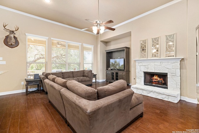 living room featuring a fireplace, ornamental molding, dark hardwood / wood-style floors, and ceiling fan