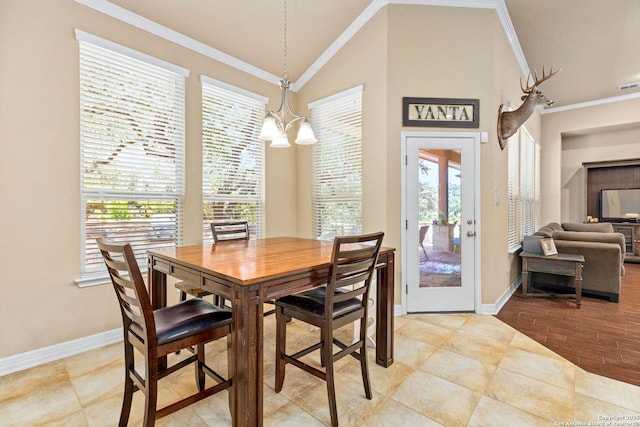 dining room with a healthy amount of sunlight, crown molding, vaulted ceiling, and a chandelier