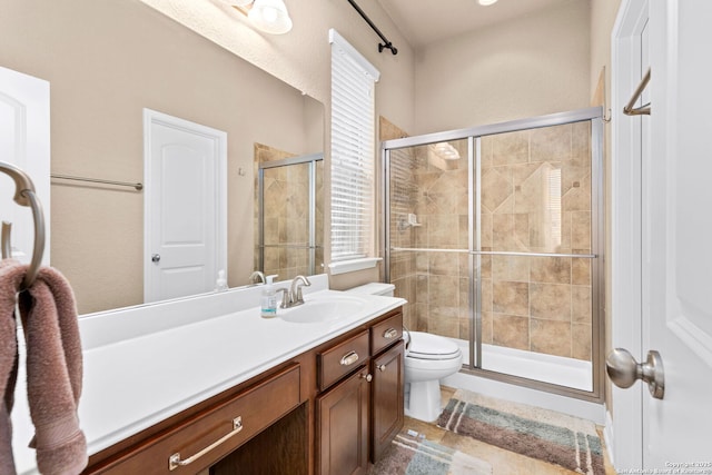 bathroom featuring vanity, an enclosed shower, and toilet