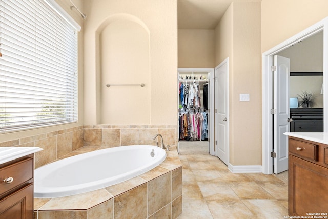 bathroom featuring vanity and tiled tub