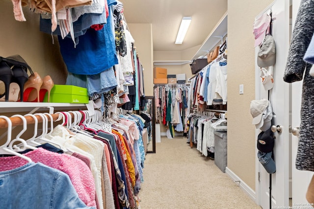 walk in closet featuring light carpet