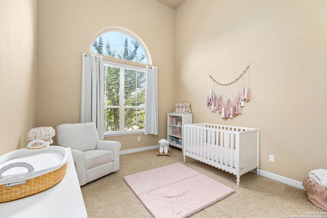 carpeted bedroom featuring a nursery area