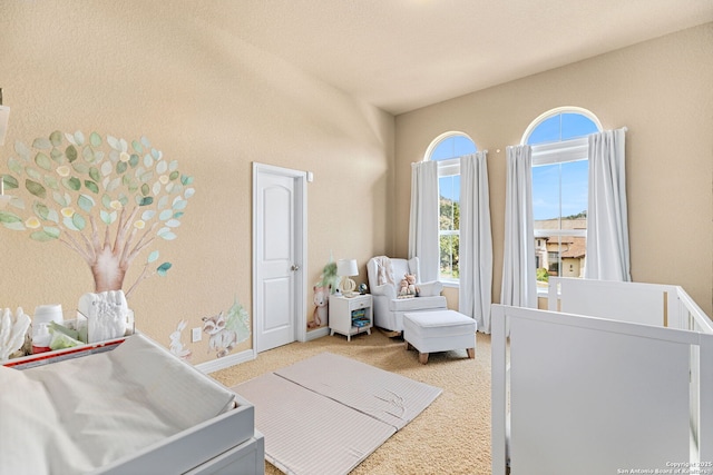 bedroom featuring a nursery area and carpet floors