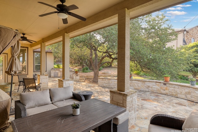 view of patio featuring ceiling fan, an outdoor living space, and exterior kitchen