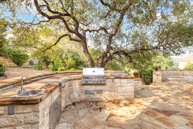 view of patio with exterior kitchen, sink, and grilling area