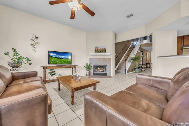 living room with light tile patterned flooring, ceiling fan, and a fireplace