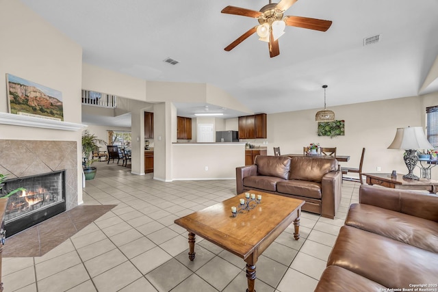 tiled living room featuring a tiled fireplace and ceiling fan