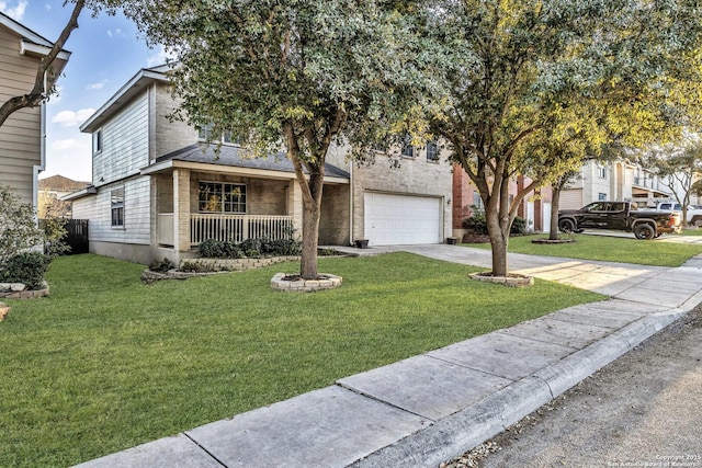 view of front of home with a garage, a front yard, and covered porch