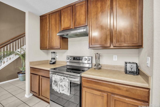 kitchen featuring light tile patterned flooring and stainless steel range with electric stovetop