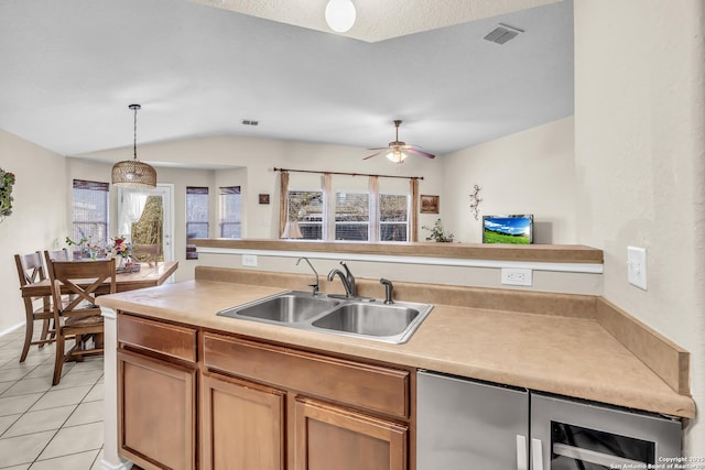 kitchen featuring a healthy amount of sunlight, decorative light fixtures, sink, and light tile patterned floors