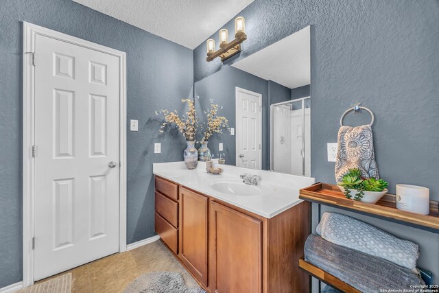 bathroom featuring vanity, tile patterned flooring, and a textured ceiling