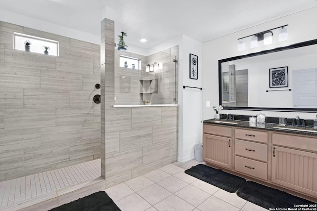 bathroom featuring tile patterned flooring, vanity, and a tile shower