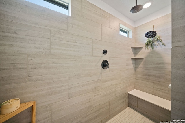 bathroom with a tile shower and plenty of natural light