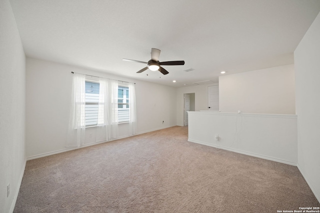 spare room with light colored carpet and ceiling fan