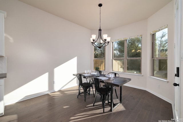 dining area with dark hardwood / wood-style flooring and a notable chandelier