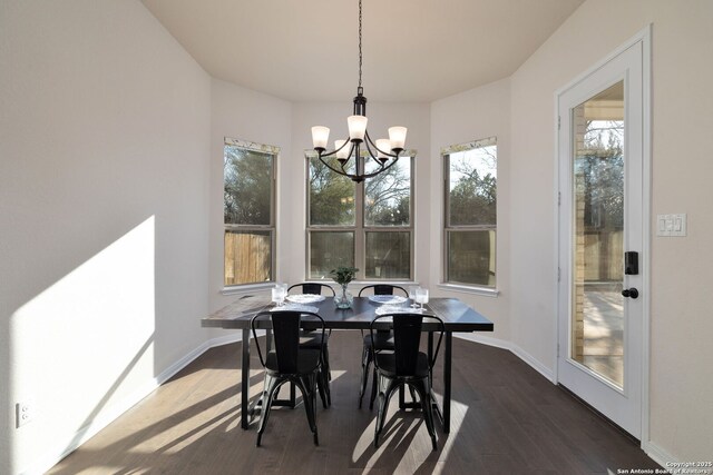 dining room with dark wood-type flooring and a chandelier