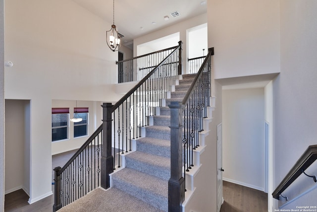 stairway featuring hardwood / wood-style floors and a high ceiling