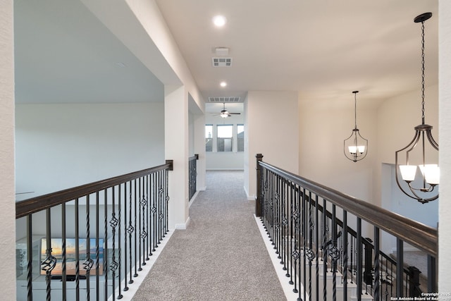 hall with carpet flooring and a chandelier