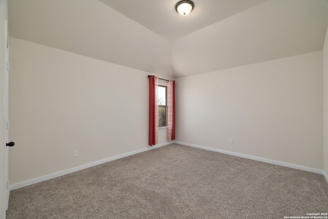 carpeted empty room with vaulted ceiling