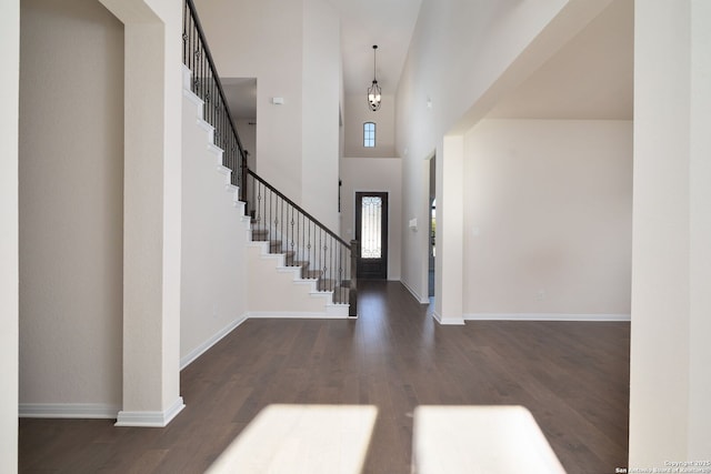 foyer entrance with dark wood-type flooring and a high ceiling