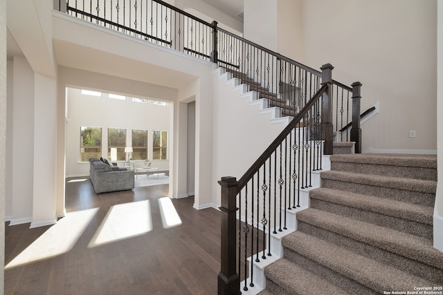 stairway featuring a high ceiling and hardwood / wood-style floors