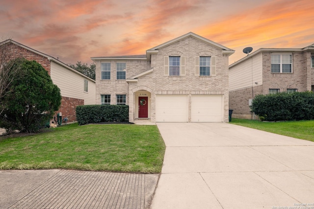 traditional home with an attached garage, driveway, brick siding, and a front yard