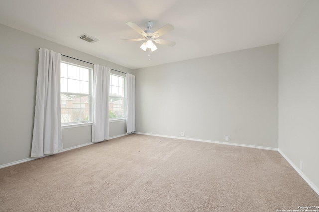 unfurnished room featuring a ceiling fan, carpet, visible vents, and baseboards