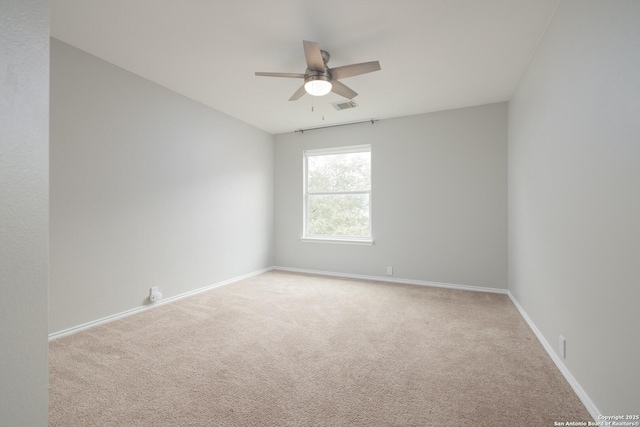 empty room featuring light carpet, baseboards, visible vents, and a ceiling fan