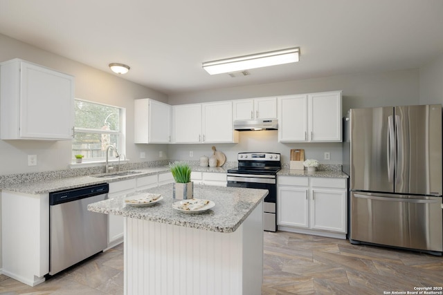 kitchen featuring white cabinets, under cabinet range hood, a kitchen island, and stainless steel appliances