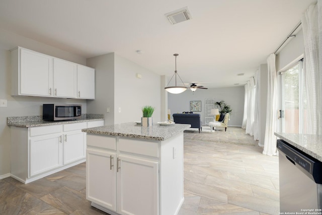 kitchen with visible vents, white cabinets, appliances with stainless steel finishes, open floor plan, and hanging light fixtures