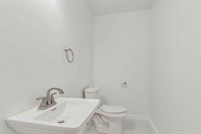 bathroom featuring toilet, tile patterned flooring, and sink