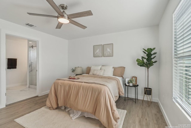 bedroom with ensuite bathroom, ceiling fan, and light hardwood / wood-style floors