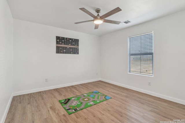 empty room with ceiling fan and light hardwood / wood-style flooring