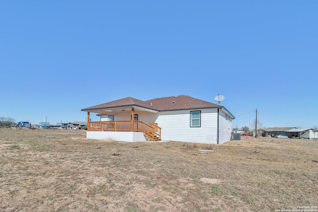 back of property featuring central AC and a lawn