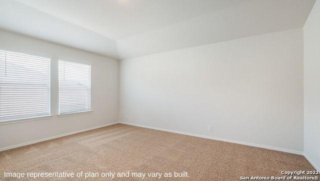 empty room featuring light colored carpet and lofted ceiling