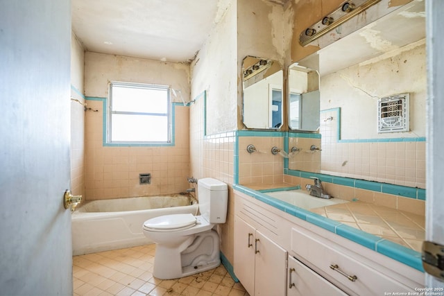 full bathroom with tiled shower / bath, vanity, toilet, and tile walls