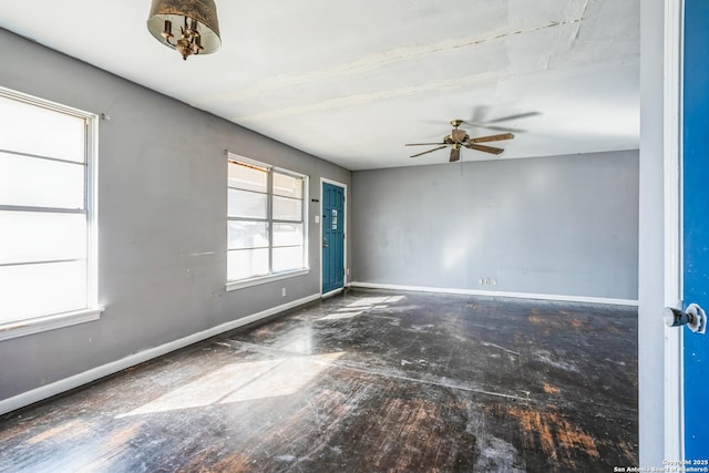 unfurnished room featuring a healthy amount of sunlight and ceiling fan