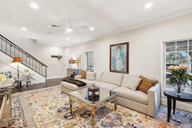 living room featuring hardwood / wood-style flooring, ceiling fan, and crown molding