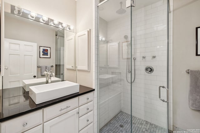 bathroom featuring a shower with door and vanity