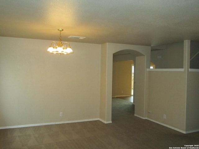 carpeted empty room with a chandelier