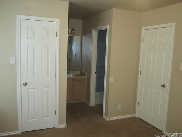 interior space with dark carpet and ensuite bathroom